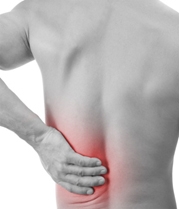 Man touches lower spine seeking back pain treatment.