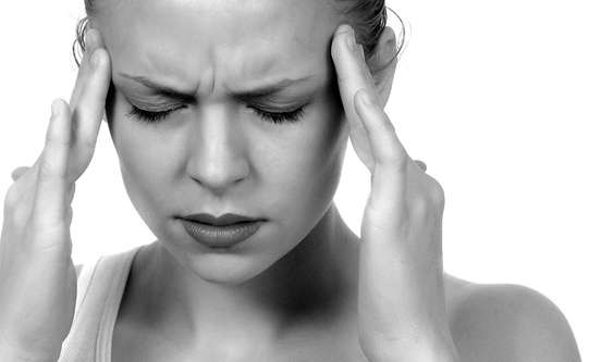 Woman suffering from a headache, in need of headache relief