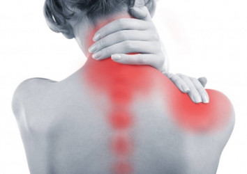 Woman grasps cervical spine and shoulder seeking neck pain treatment
